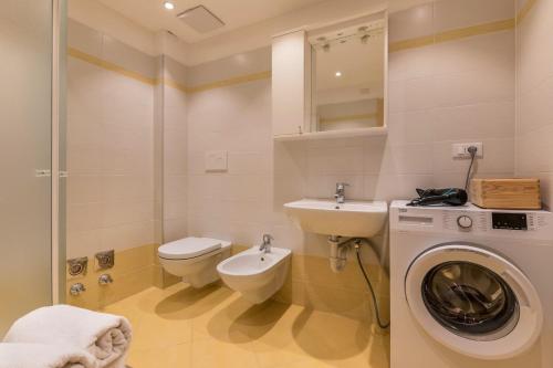 a bathroom with a washing machine and a sink at Buffaure a parte in Pozza di Fassa
