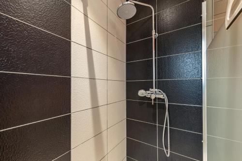 a bathroom with a shower with black and white tiles at Maison 4 pers à 5kms de la plage in Plouider