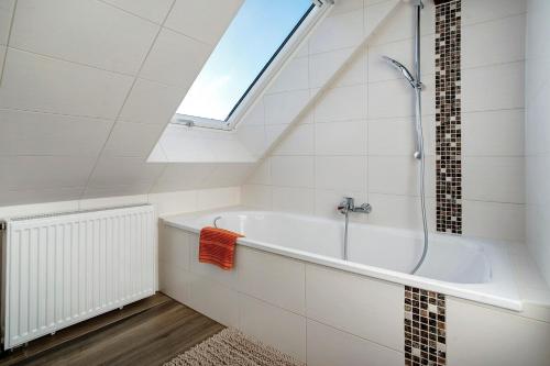 a bathroom with a bath tub and a skylight at gemütliche Ferienwohnung in Seenähe in Neustrelitz