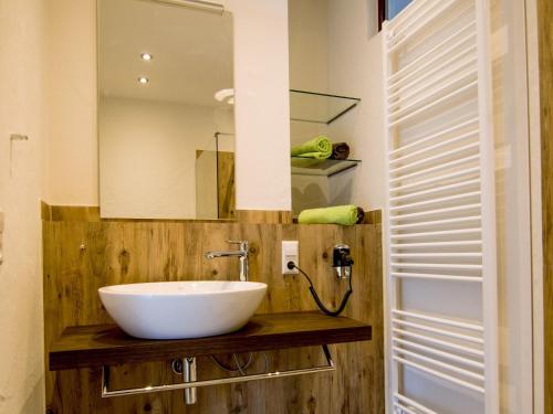 a bathroom with a white sink and a mirror at Ferienwohnung Maulbetsch in Alpirsbach