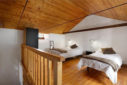two beds in a room with a wooden ceiling at Casa Fagundo 84 in Alajeró