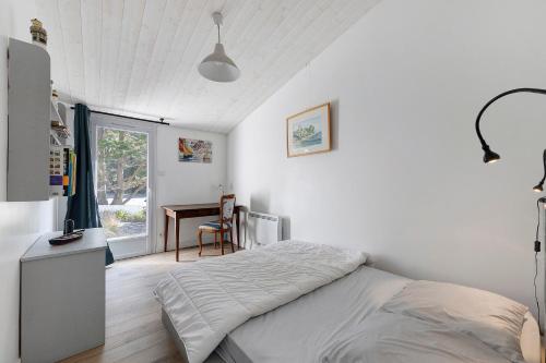 a white bedroom with a bed and a desk at Ile de Noirmoutier - Maison T4 in La Guérinière
