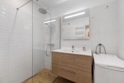 a white bathroom with a sink and a shower at Ile de Noirmoutier - Maison T4 in La Guérinière