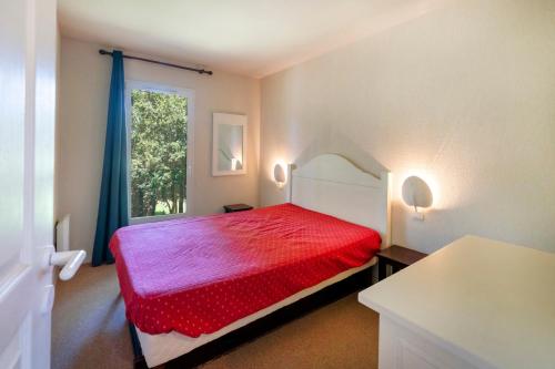 a bedroom with a red bed and a window at Domaine de Pinsolle in Soustons