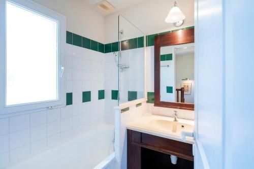 a bathroom with a sink and a shower and a mirror at Domaine de Pinsolle in Soustons
