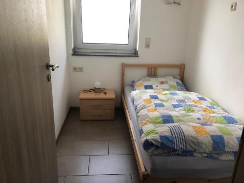 a small bedroom with a bed and a window at Fewo Stremme in Altenlotheim
