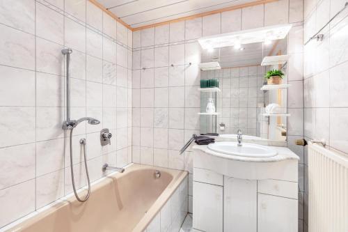 a bathroom with a tub and a sink and a bath tub at Ferienwohnung Käppeleblick in Bernau im Schwarzwald