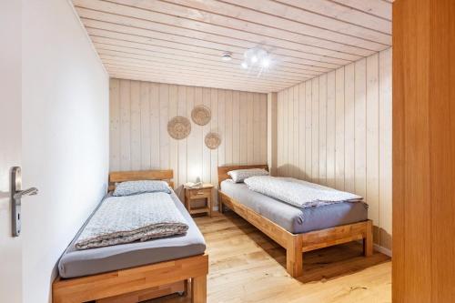 two twin beds in a room with wooden floors at Ferienwohnung Käppeleblick in Bernau im Schwarzwald