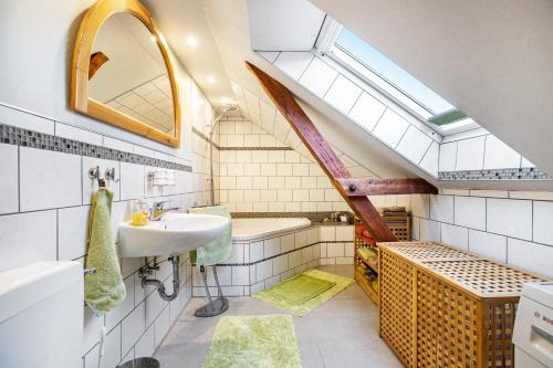 an attic bathroom with a sink and a skylight at Ferienwohnung am Töschenbach in Hennstedt