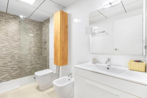 a white bathroom with a toilet and a sink at Sungolfbeach El Girasol in Orihuela