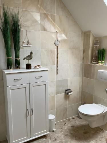 a bathroom with a toilet and a sink at Uhlenhoff Boyken in Bokellerostermoor