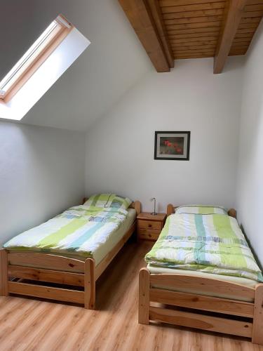 two beds in a room with white walls and wooden floors at Uhlenhoff Boyken in Bokellerostermoor