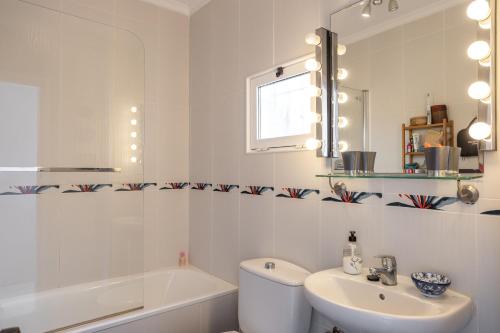 a bathroom with a sink and a toilet and a mirror at Plaza Cadiz 4 overlooking Playazo in Nerja