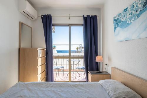 a bedroom with a bed and a view of the ocean at Plaza Cadiz 4 overlooking Playazo in Nerja