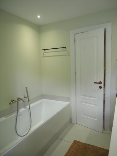 a white bathroom with a tub and a shower at El Cafetal de Veronica in Marbella