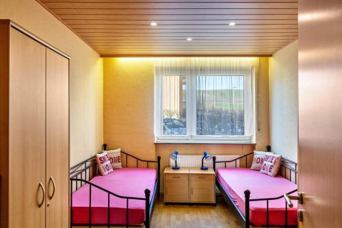 two beds in a room with a window at Haus Zum Rochusberg 2 in Bingen am Rhein
