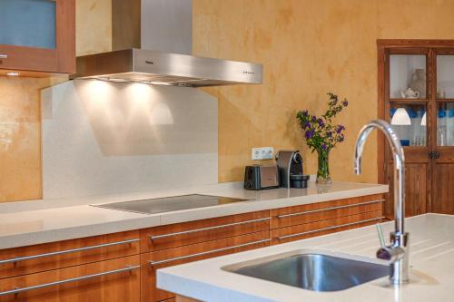 a kitchen with a sink and a stainless steel hood at Casa Caterina in Port de Soller