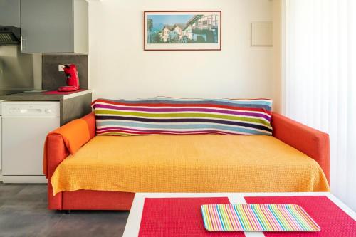 an orange couch in a kitchen with a table at Appartement de charme - spa privé in Biarritz