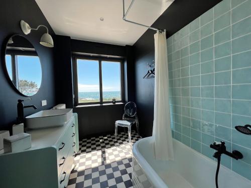 a bathroom with a tub and a sink and a bath tub at La Perle in Plobannalec-Lesconil