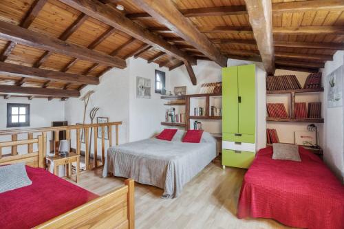 two beds in a room with wooden ceilings at Maison Am Stram Gram in La Tranche-sur-Mer