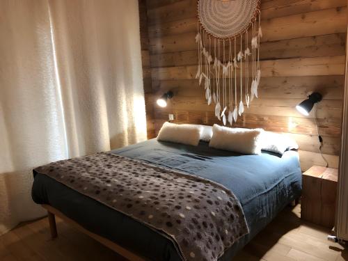 a bedroom with a bed with a wooden wall at La Baïta De La Foux in La Foux d'Allos