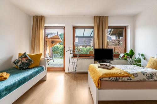 a bedroom with a bed and a couch and a television at Ferienwohnung Davio in Lohe-Rickelshof