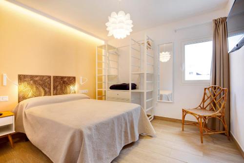 a bedroom with a bed and a chair and a window at Falco 2 in La Oliva