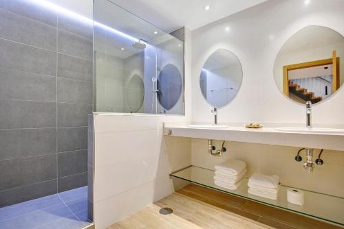 a bathroom with a sink and two mirrors at Falco 2 in La Oliva