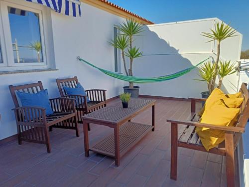 a patio with chairs and a table and a hammock at T2 Moliceiros Torreira vista Ria in Torreira