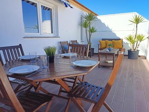 a wooden table and chairs on a patio at T2 Moliceiros Torreira vista Ria in Torreira