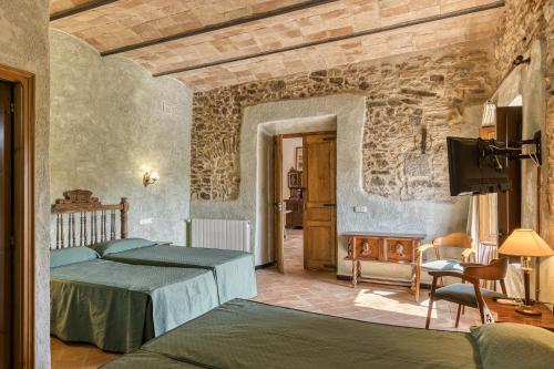 a bedroom with a bed and a tv in a room at Can Casadellà in Serra de Daró