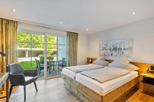 a bedroom with a large bed and a desk and a chair at Doppelzimmer Mit Terrasse in Schmallenberg