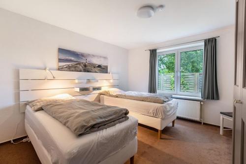 a bedroom with two beds and a window at Ferienhaus Sprante in Brunsbüttel