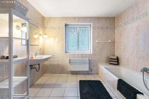 a bathroom with a tub and a sink at Ferienhaus Sprante in Brunsbüttel