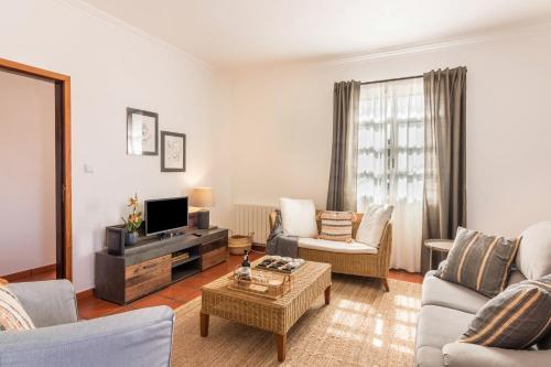a living room filled with furniture and a tv at Casa da Olides - T3 in Santana