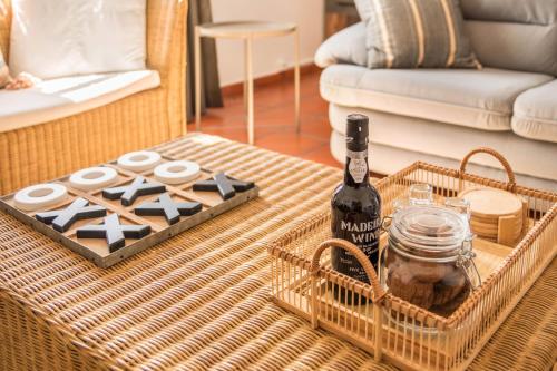 a bottle of wine on a table in a living room at Casa da Olides - T3 in Santana