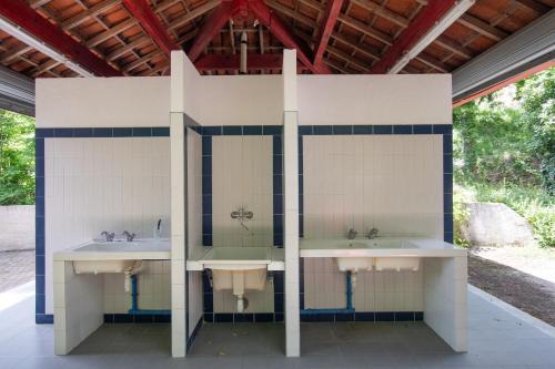 a bathroom with three sinks and two mirrors at la pêcherie in Malbosc