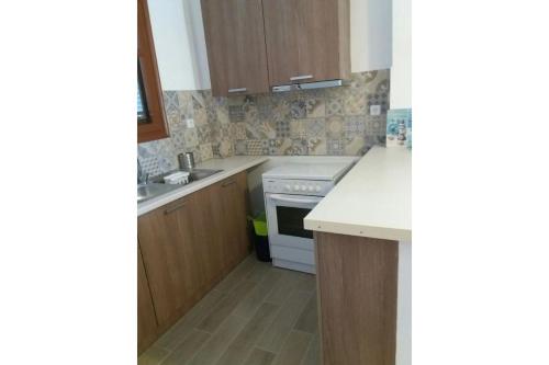 a kitchen with a sink and a stove at Μaria's house 1 in Ilia