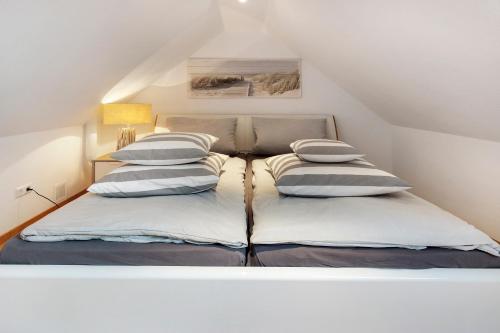 a bed with four pillows on it in a attic at Hannover Südstadt-Perle in Hannover