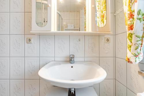 a bathroom with a white sink and a mirror at Haus Seeblick in Putbus