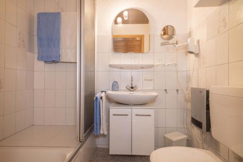 a white bathroom with a sink and a toilet at Ferienhof Wetzel Fewo 1 in Hergensweiler