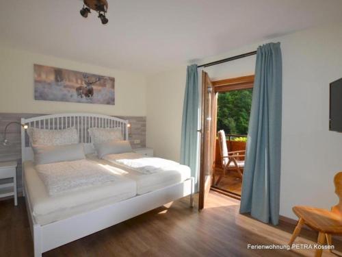 a bedroom with a bed and a sliding glass door at Ferienwohnung Petra in Kössen