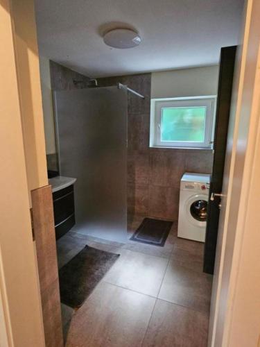 a bathroom with a washing machine and a window at Ferienwohnung Petra in Kössen
