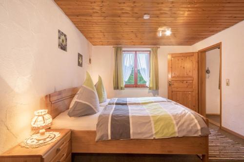 a bedroom with a bed and a window at Ferienhof Wetzel Fewo 1 in Hergensweiler