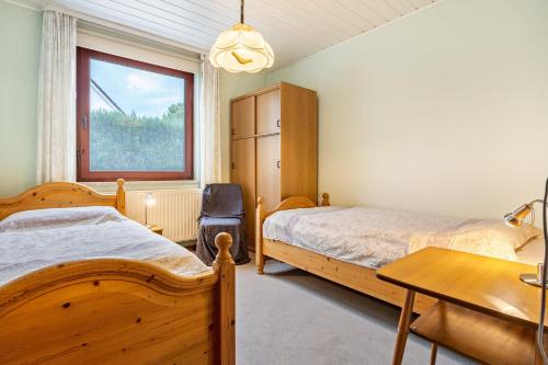 a bedroom with two beds and a desk and a window at Haus Seeblick in Putbus