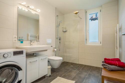 a bathroom with a washing machine and a sink at Sunny Appartment in Bregenz