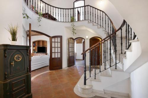 a staircase in a home with white walls and wrought iron railings at Villa Rústica in Albufeira