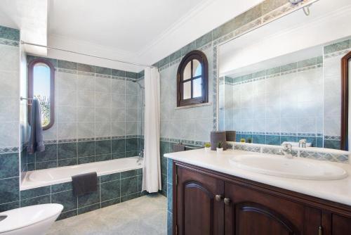 a bathroom with a sink and a tub and a toilet at Villa Rústica in Albufeira