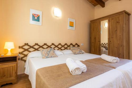 a bedroom with two beds with towels on them at La Vinya del Beato 1950 in Port de Pollensa