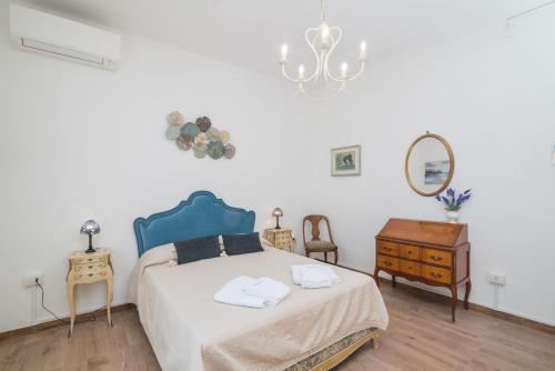 a bedroom with a bed and a table and a chandelier at Maison Chloe 2 in La Maddalena